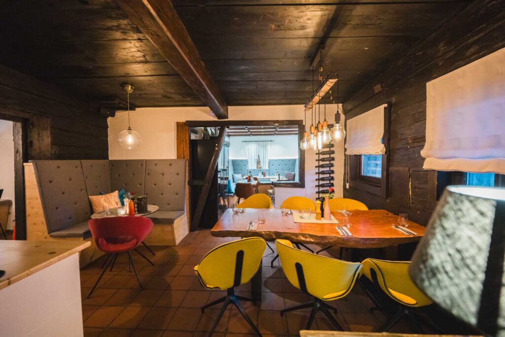 Blick in das Restaurant mit einer Mischung aus modernen und rustikalen Möbeln.
